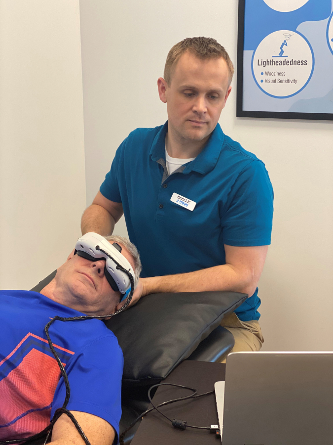 Photo courtesy of Mike Teater 
 Physical therapist Mike Teater (right), co-owner of the Camas-based FYZICAL Therapy and Balance Center, demonstrates on a volunteer the postures and infrared goggles used to help treat a form of vertigo that can cause severe dizziness.