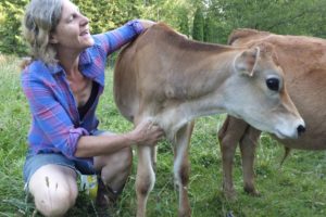 Colibri Gardens owner Lara Scanlon pets a calf at her Washougal farm. (Contributed photo courtesy of Lara Scanlon)