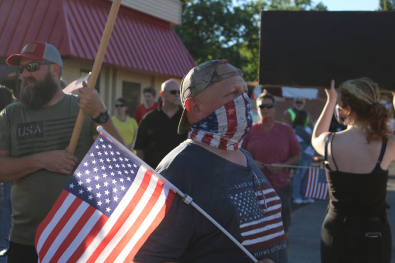A man holds an American flag at a pro-police &quot;Back the Blue&quot; rally in downtown Camas on Friday, Aug. 28.