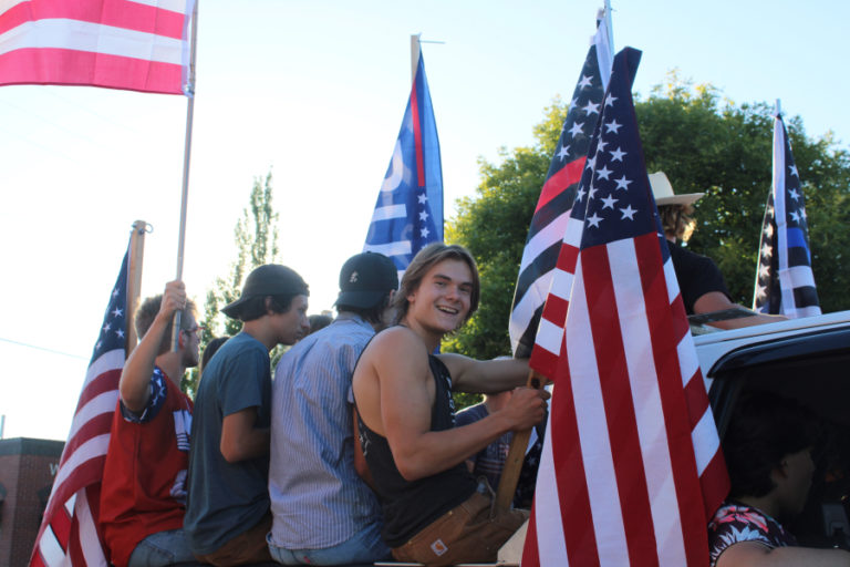 Young men riding in the back of a pickup truck that sped through downtown Camas dozens of times during a pro-police &quot;Back the Blue&quot; rally on Friday, Aug.