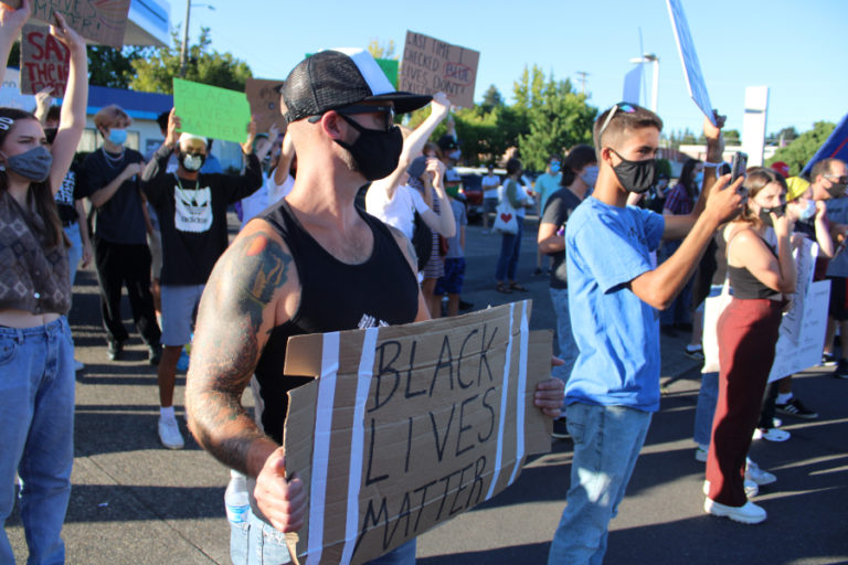 People wearing masks to help stop the spread of COVID-19 hold signs stating &quot;Black Lives Matter&quot; at the corner of Northeast Dallas Street and Northeast Third Avenue in downtown Camas during a counterprotest to a pro-police &quot;Back the Blue&quot; rally on Friday, Aug.