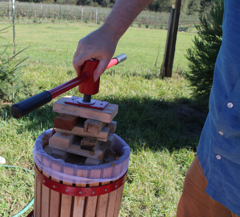 Andy Gerzel, of Portland, twists the handle of an apple cider press at Columbia Gorge Vintners on Sunday, Sept.