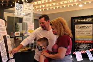 Anna Presley (right) and Joe Costa (left, white shirt) and Lucas Kellum, all of Ridgefield, order food at the box office off the Liberty Theatre in downtown Camas on Friday, Oct. 9. The trio was the first to show up for the Liberty Theatre's first show in seven months -- the Goonies, which showed at 4 p.m. Friday. The historic theater, which closed in March due to the COVID-19 pandemic, is now able to seat 75 people per show, with safety restrictions such as required face coverings and new concession rules, thanks to Gov. Jay Inslee's Oct. 6 changes to the state's Safe Start reopening plan, which loosened restrictions for theaters, restaurants, realtors, libraries and more throughout Washington state. (Photos by Kelly Moyer/Post-Record)