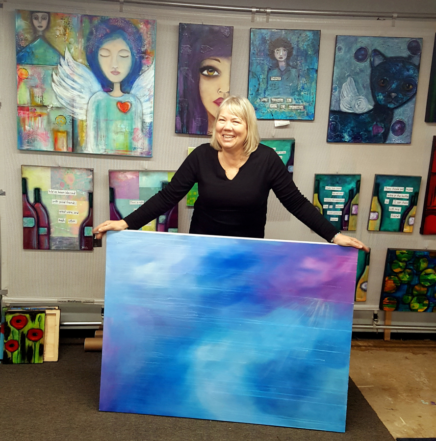 Painter Tamara Dinius holds an oil painting in her Washougal art studio. (Contributed photo courtesy of Tamara Dinius)