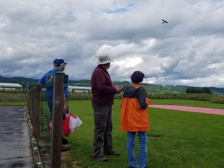 Robert Overgaard (left), Bruce Wasill (center) and Owen Childers (right) fly a model airplane at the Port of Camas-Washougal industrial park in June 2020.