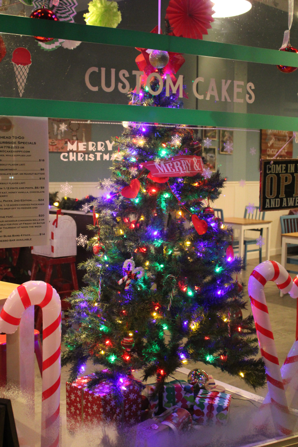 A festive, lighted holiday tree and candy canes decorate the front window of Cake Happy in downtown Camas during the Downtown Camas Association's First Friday event on Dec.