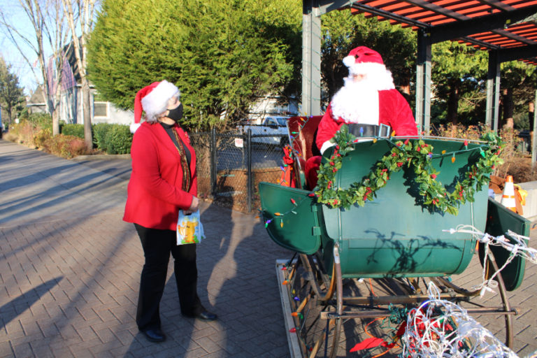Washougal Mayor Molly Coston tells Santa she is hoping for world peace this year, during the city's "Ho, Ho, Holidays" drive-thru event in downtown Washougal on Saturday, Dec.