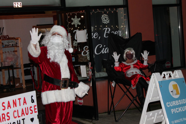 Santa and Mrs. Claus wave to passersby outside Salud! Wine Bar at 224 N.E. Third Ave., in Camas on Friday, Dec.