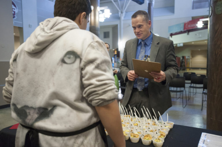 Camas School District Superintendent Jeff Snell talks with a middle school student about food he prepared in a 2016 Iron Chef-style healthy cooking contest in Camas.