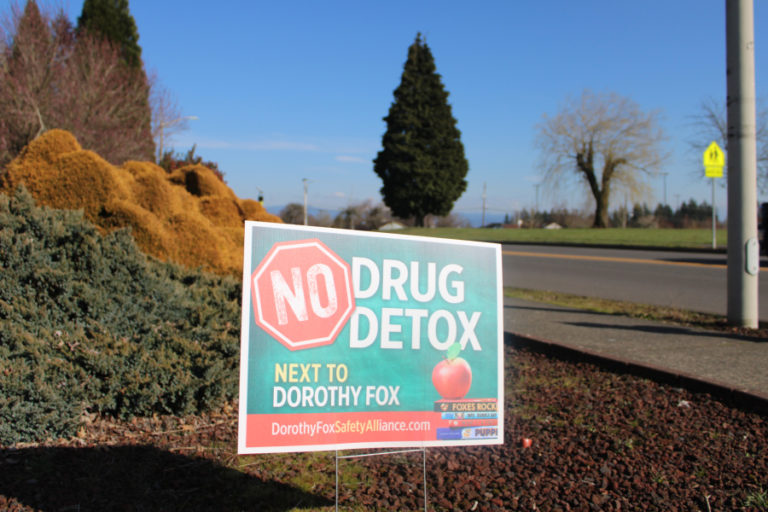 A "No Drug Detox Next to Dorothy Fox" sign stands at the corner of Northwest 28th Avenue and Northwest Utah Street, across from the Camas elementary school, on March 16, 2021.