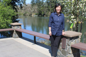 Camas Parks and Recreation Director Trang Lam stands outside the city-owned Lacamas Lake Lodge, overlooking Lacamas Lake, on Monday, April 12, 2021. (Kelly Moyer/Post-Record)
