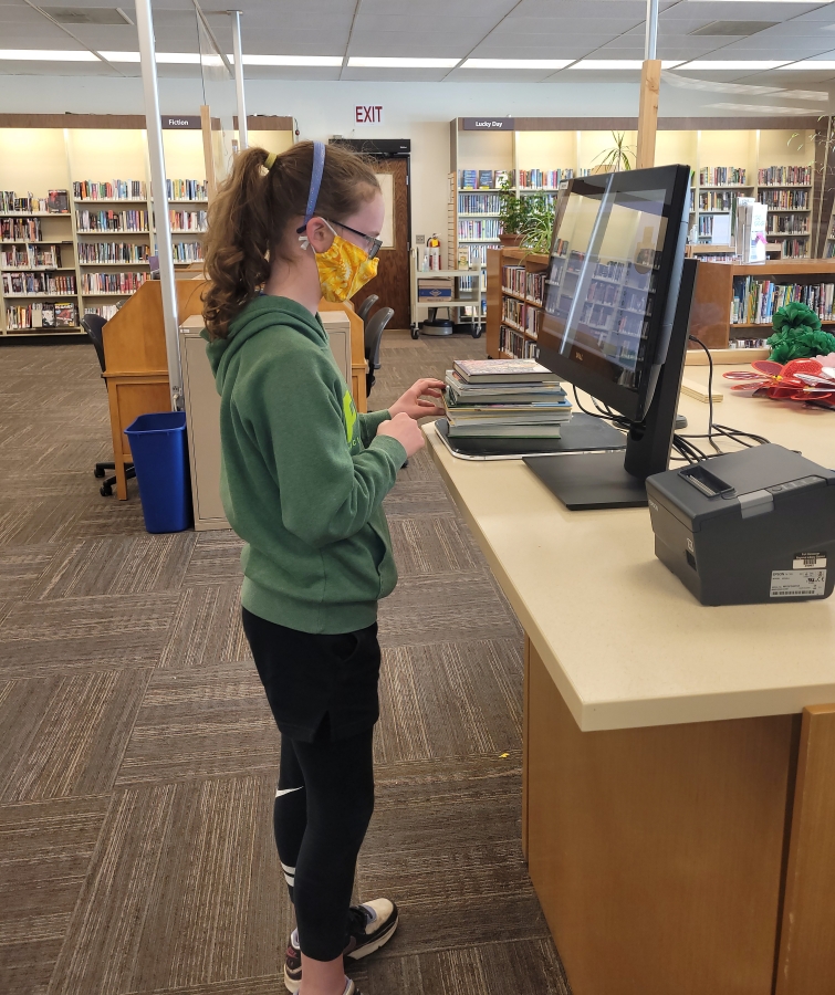 A Washougal Community Library patron checks out a book on Monday, April 20, the first day of the facility&#039;s reopening.