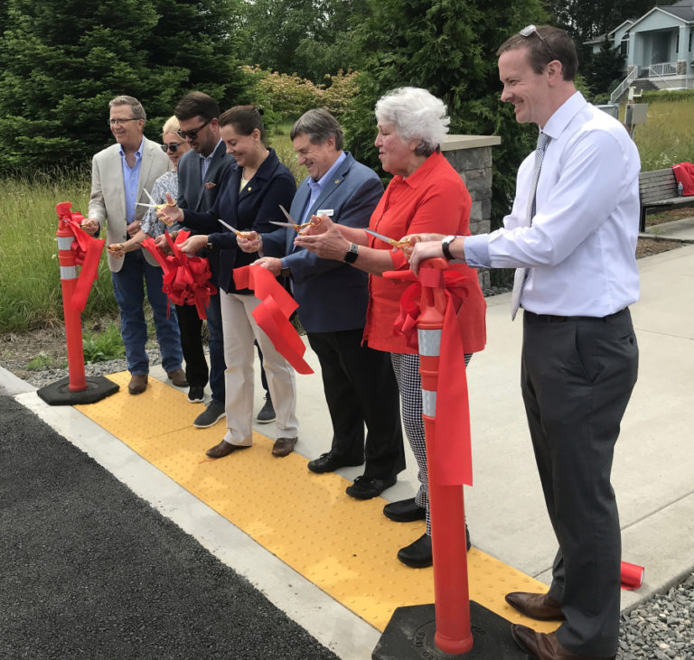 A group of local and regional dignitaries, including state Sen. Ann Rivers (fourth from left) state Reps. Larry Hoff (far left) and Brandon Vick (third from left), Washougal Mayor Molly Coston (second from right) and Port of Camas-Washougal Commissioner Larry Keister (third from right) cut a ribbon during a ceremony to commemorate the completion of the Columbia River Connector Trail on Monday, June 7, 2021.