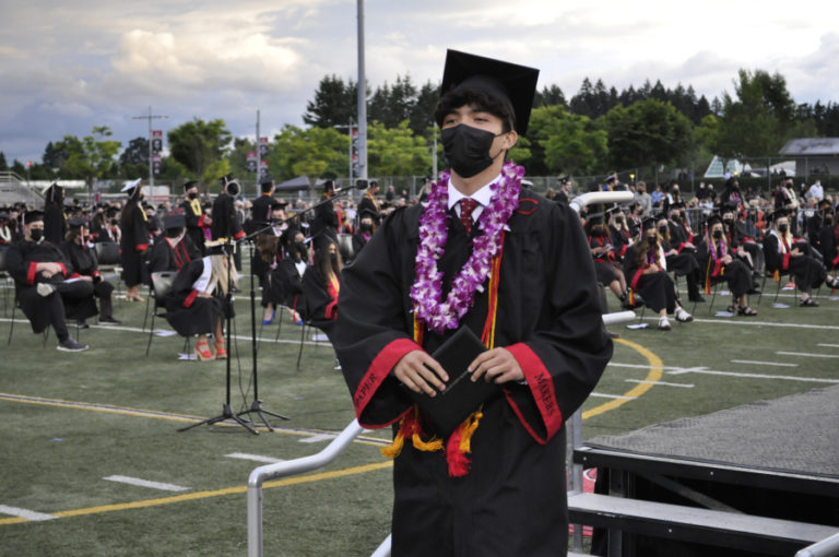 Camas High School seniors, wearing face coverings to prevent the spread of COVID-19, listen to speakers at their class of 2021 high school graduation ceremony on Friday, June 11, 2021, at Doc Harris Stadium in Camas.