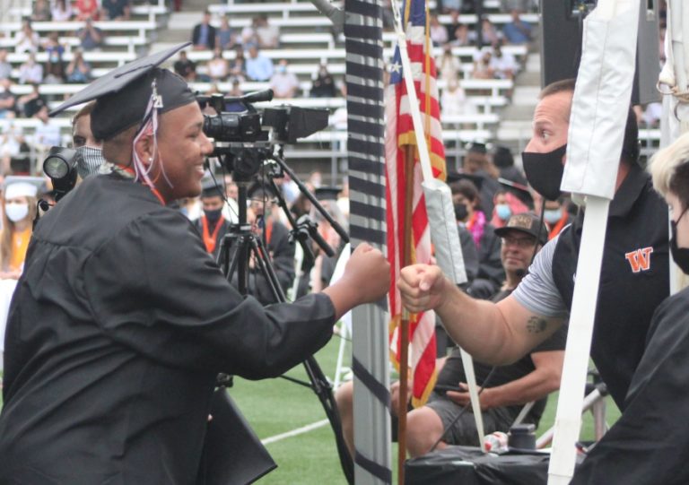 A Washougal High School senior gets a fist-bump before their high school&#039;s class of 2021 graduation ceremony, held  Saturday, June 12, 2021, at Fishback Stadium in Washougal.