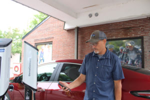 Ed Fischer shows how a smartphone app turns on one of the two SemaConnect electric vehicle charging stations he recently installed in downtown Camas, outside Camas Bike & Sport, at 403 N.E. Fifth Ave., on Thursday, July 1, 2021. (Photos by Kelly Moyer/Post-Record)
