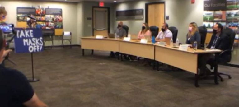 Liz Rondeau (left) the parent of three Camas High School graduates, holds a sign stating, &quot;Take Masks Off!&quot; while speaking to the Camas School Board on Monday, July 26, 2021.