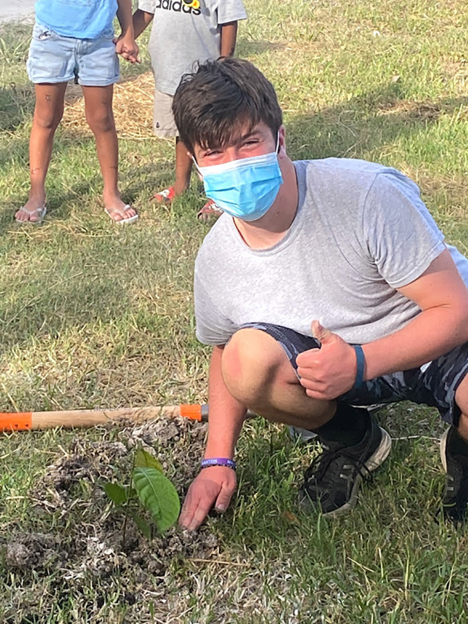 Washougal High School student Blake Scott plants a mohogany tree as part of a "cultural exchange" during an educational tour of Belize in July.