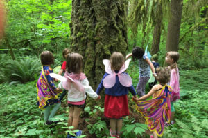 Children dress up and gather around a tree at the TreeSong Nature Awareness and Retreat Center's  2018 "Run Wild!" event in Camas.