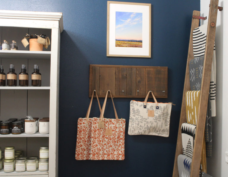 Hand silk-screened canvas bags by Maine artist Erin Flett and a print of Powell Butte by Portland landscape artist Catherine Freshley hang next to a display of Seek and Swoon blankets inside Poppy & Hawk, a new downtown Camas gift shop, on Thursday, Aug. 26, 2021.