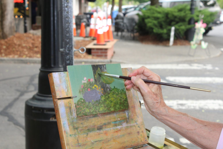 Artist Beth Norwood works on an oil painting of a Camas flower basket in downtown Camas during the 2021 Plein Air art event on Friday, Sept.