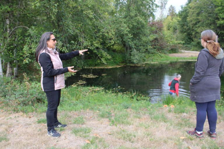 Lacamas Shores resident Marie Tabata Callerame (left) talks to Camas resident Deborah Nagano (right) about the state of the Lacamas Shores biofilter while Camas resident Susan Knilans (center) wades into a nearby settling pond to check for signs of wildlife, including bugs, frogs and fish, on Friday, Sept.