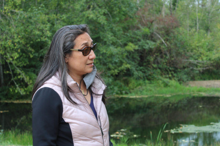 Lacamas Shores resident Marie Tabata Callerame stands near a settling pond on the edge of the Lacamas Shores biofilter on Friday, Sept.