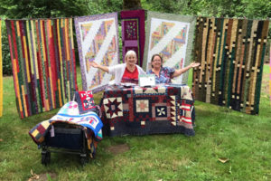 Members of the Cape Horn Quilters show off some of their group's quilts outside the Washougal-based American Legion Cape Horn Post 122 building in July 2021. (Contributed photo courtesy of Peri Muhich)