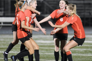 Camas soccer player Lily Loughney (left) jumps on the back of Emerson Grafton (18) after Grafton scored a goal during the Papermakers' first-round 4A state tournament game against Kennedy Catholic at Doc Harris Stadium on Nov. 10, 2021. (Contributed photo courtesy of Kris Cavin)