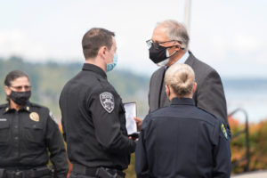 Washington Gov. Jay Inslee (right) presents Washougal police officer Francis Reagan (second from left) with a Washington State Law Enforcement Medal of Honor on Oct. 8, 2021. (Photo by Heather Davis, courtesy of Washington State Patrol)