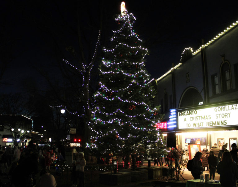 Visitors to downtown Camas take photos in front of the city’s lighted holiday tree, in front of the Liberty Theatre, during the city of Camas’ 2021 Hometown Holidays event on Friday, Dec. 3, 2021. (Kelly Moyer/Post-Record)