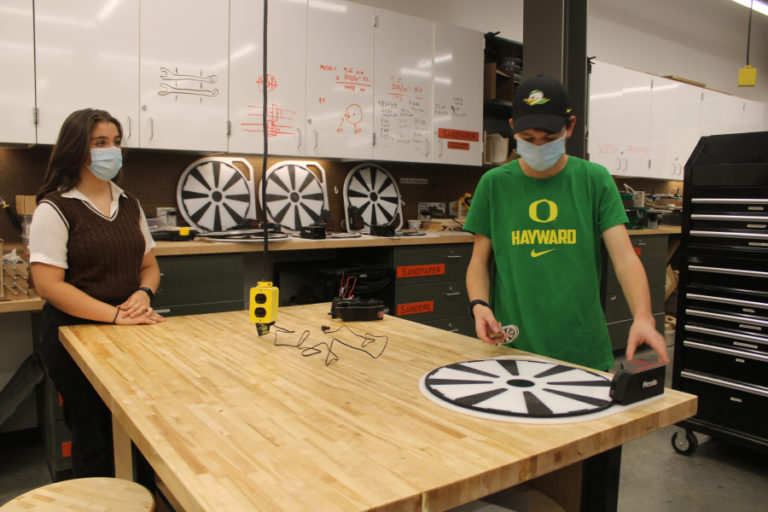 Silvia Pujol, 13, a freshman at Discovery High School (left) and Jack Harding, 15, a sophomore at Discovery High (right) discuss the work that went into creating their Power Pivot health care device inside Discovery High's STEM lab on Wednesday, Dec. 1, 2021.