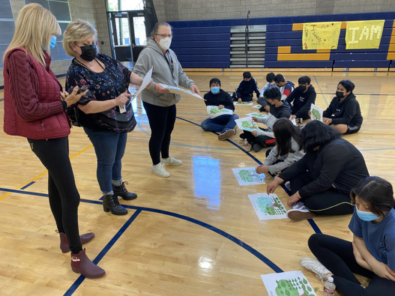 Washougal School District Spanish-speaking family liaison coordinator Sandy Renner (left) and Jemtegaard Middle School counselor Kirstin Albaugh (second from left) work with students on a family tree project during a La Chispa session in May 2021.