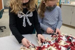 Washougal first-graders Quinn Henry (left) and Naomi Vest make a blanket for West Columbia Gorge Humane Society shelter animals at Cape Horn-Skye Elementary School in Washougal in December 2021. (Contributed photo courtesy of the Washougal School District) 