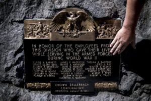 Ryan Hickey, operations specialist with the city of Camas, shows in August 2019 where damage had previously been located on a memorial for Camas mill workers who died serving in World War II. (Contributed photo courtesy of The Columbian files)