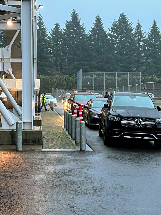 Vehicles carrying Camas School District students and staff who have either experienced COVID-19 symptoms or been identified as a close contact of a COVID-positive individual line up at the school district&#039;s COVID-testing site at Doc Harris Stadium in Camas on Tuesday, Jan. 18, 2022.
