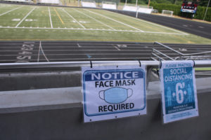Signs calling for masking and distancing to prevent the spread of COVID-19 are displayed at Hayes Freedom's high school graduation ceremony, held at Doc Harris Stadium in Camas on June 12, 2021. (Kelly Moyer/Post-Record files)