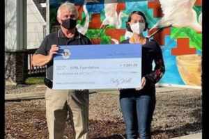 Camas Lions Club President Brian Scott (left) presents Washougal Community Library Branch Manager Rachael Ries (right) with a $1,001 check to help fund the new Washougal library building. Lone Wolf Development has donated land for a new library on Durgan Street between Main and 