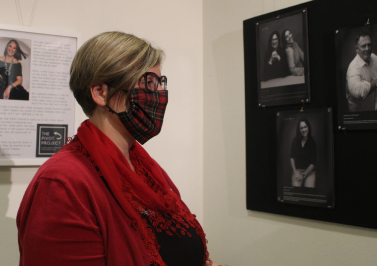 Camas Public Library Director Connie Urquhart views portraits of downtown Camas business owners during the opening night of Camas photographer Lara Blair's "Pivot Project" art show at the Second Story Gallery on Dec. 3, 2021.