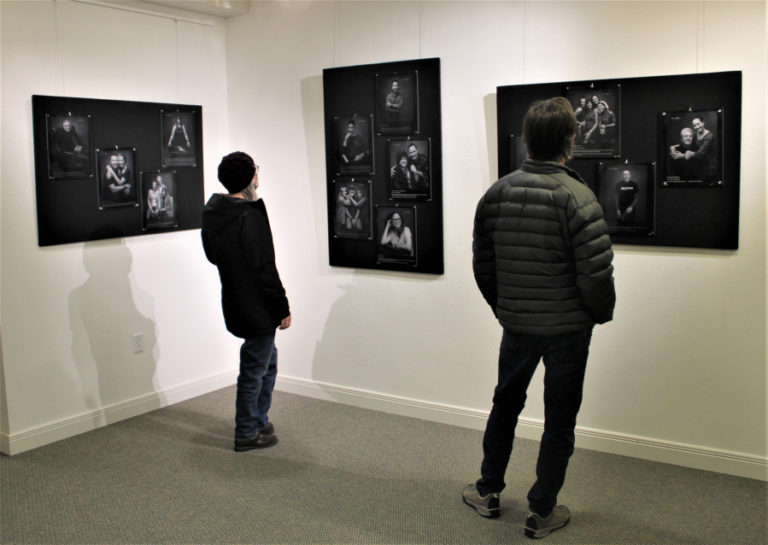 Visitors to the Second Story Gallery, located inside the Camas Public Library, view portraits of downtown Camas business owners during the opening night of Camas photographer Lara Blair's "Pivot Project" art show on Dec. 3, 2021.