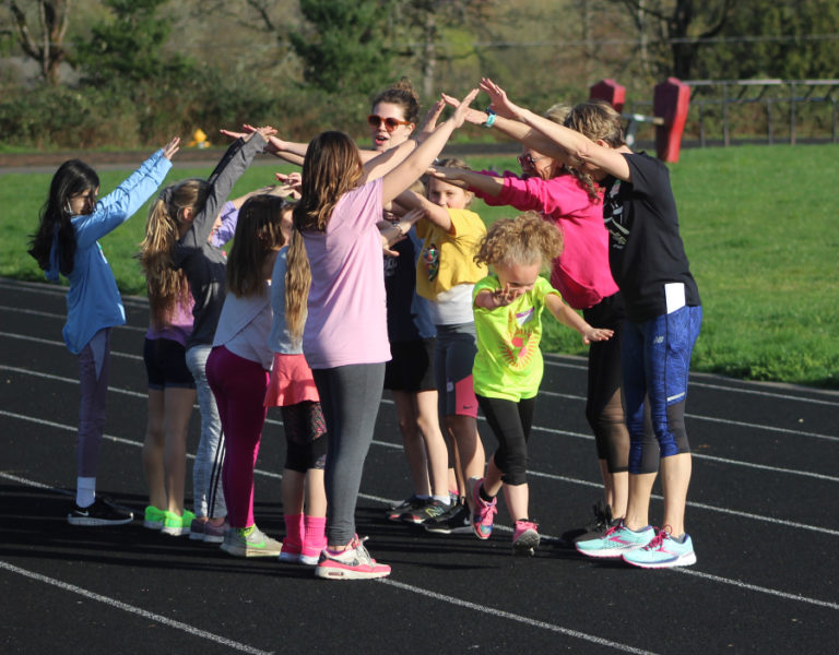 Gause Elementary School third-grade student Athena Ligons (front, center) runs through a &quot;tunnel&quot; of teammates and coaches during a Washougal Girls on the Run practice at Columbia River Gorge Elementary School on March 23, 2022.