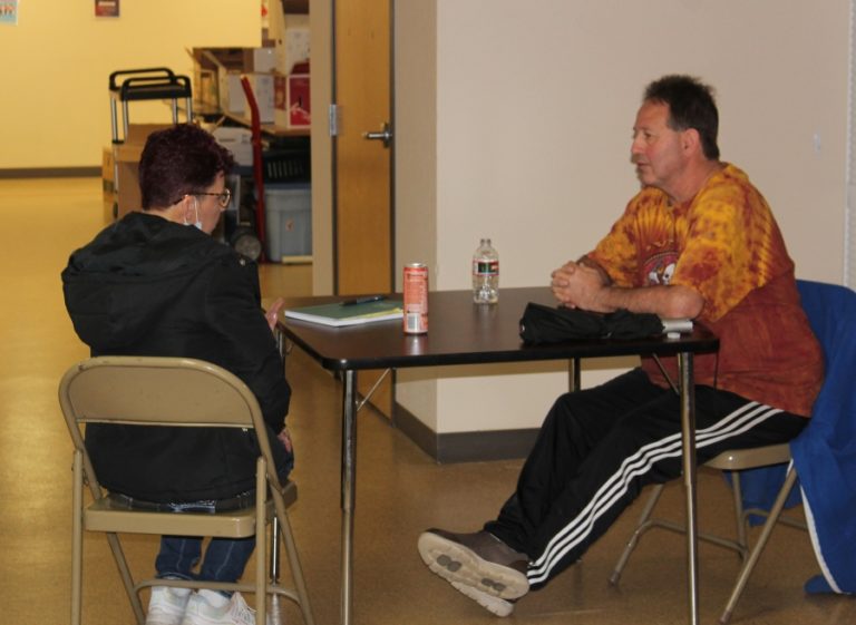 Recovery Cafe Clark County recovery coach Jodene Stonebarger (left) talks with a man in the Washougal-based Recovery Cafe on Monday, April 18, 2022.