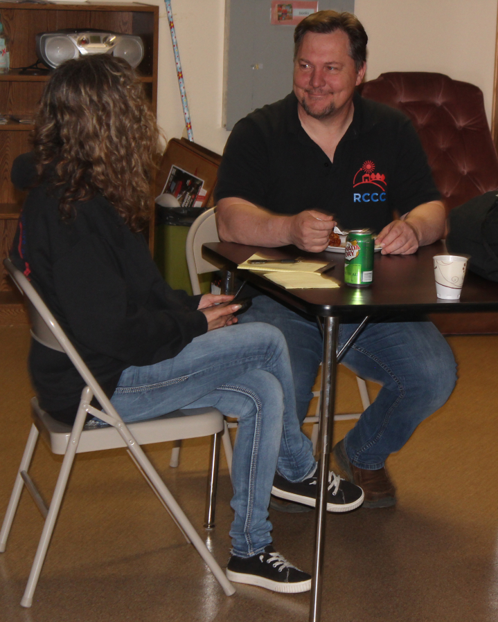 Recovery Cafe Clark County recovery coach supervisor Ethan Gonzales (right) talks with a woman in the Washougal-based Recovery Cafe on Monday, April 18, 2022.