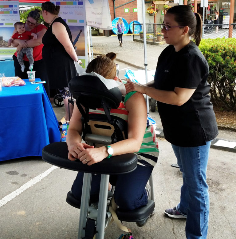 A Pure Wellness  Chiropractic employee massages a woman at the Camas Farmer&#039;s Market in 2017. The Camas-based clinic is one of 16 local health and wellness providers scheduled to participate in the inaugural Ripple Wellness Health Fair on Wednesday, June 1, at the first Camas Farmer&#039;s Market of 2022.