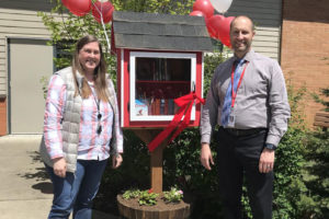 Cape Horn-Skye Elementary School teacher Darcy Hickey (left) and principal Brian Amundson attend a ribbon-cutting ceremony to celebrate the debut of the school's new "little free library" on Wednesday, May 11, 2022. (Contributed photo courtesy of the Washougal School District)