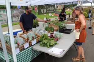 Camas Farmer's Market program coordinator Tina Eifert (right) buys produce from Yacolt Farm and Nursery at the first market of 2022 in downtown Camas on Wednesday, June 1, 2022. (Doug Flanagan/Post-Record files)