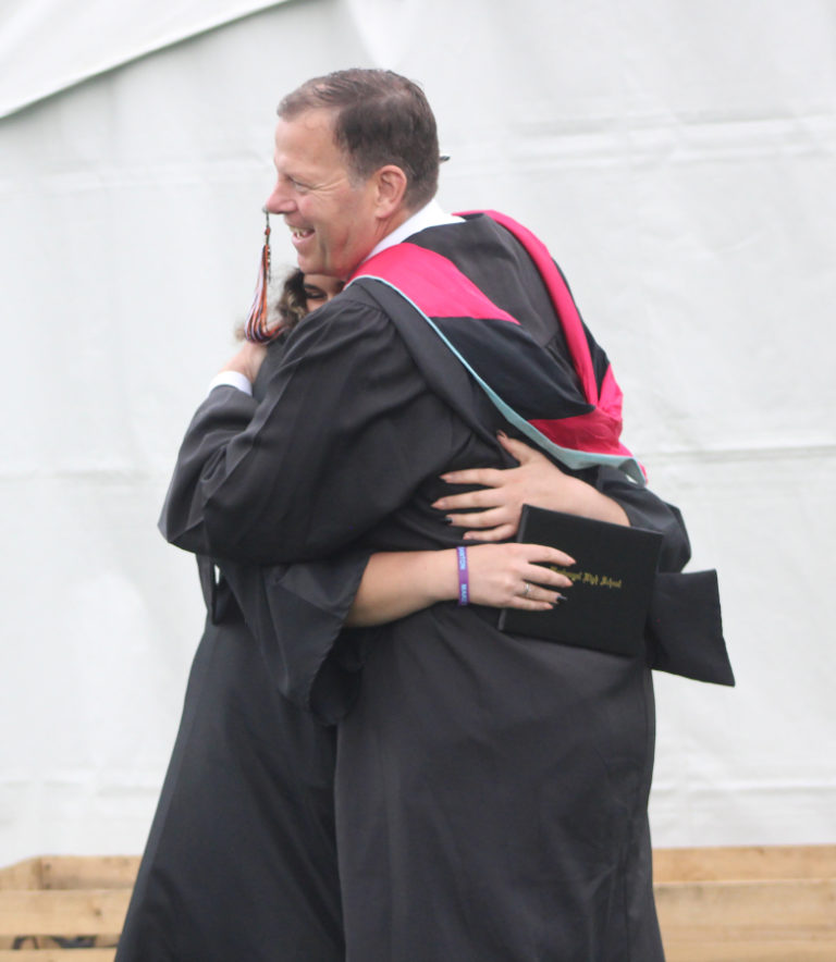 Doug Flanagan/Post-Record 
 Washougal School District assistant superintendent Aaron Hansen hugs a graduate during the Washougal High School class of 2022 commencement ceremony at Fishback Stadium on Saturday, June 11.