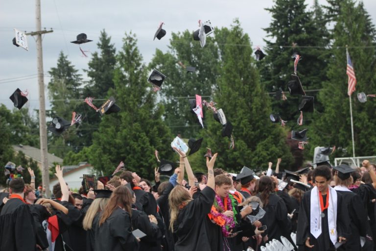 Washougal High School graduates throw their mortarboards into the air at the conclusion of their commencement ceremony at Fishback Stadium in Washougal on Saturday, June 11, 2022.