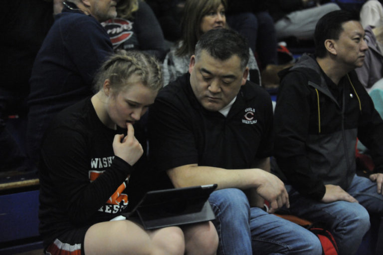 Camas girls wrestling coach Mark Yamashita advises a Washougal wrestler during a Region 3 wrestling meet in Kelso, Wash., on Feb. 15, 2020.