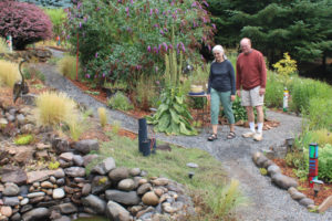 Marge and Ken Crouch walk in their Camas garden in 2021. The Crouches' "Hill of a Garden" is one of three Camas-Washougal gardens included in the 2022 Natural Garden Tour on July 17. (Kelly Moyer/Post-Record files)